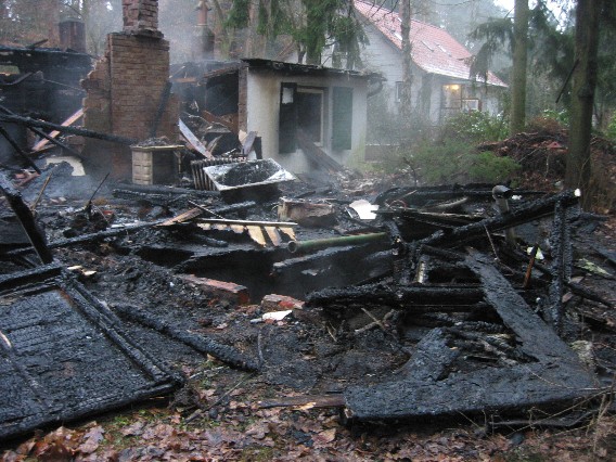 abgebrannter Vorderbereich des Bungalows bei Tageslicht